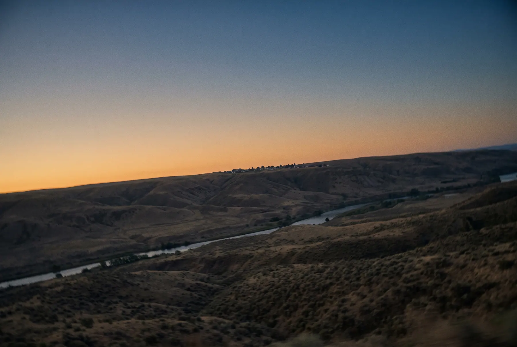 High desert landscape outside Albuquerque at first light, a river winding beneath a warm horizon.